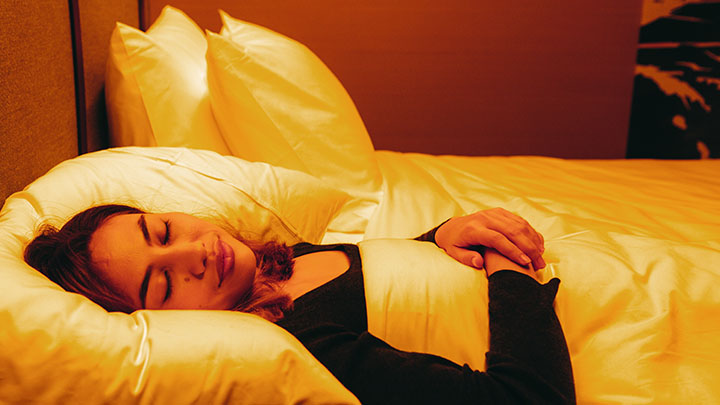 一位女士正在配备生物适应照明的酒店房间中睡觉